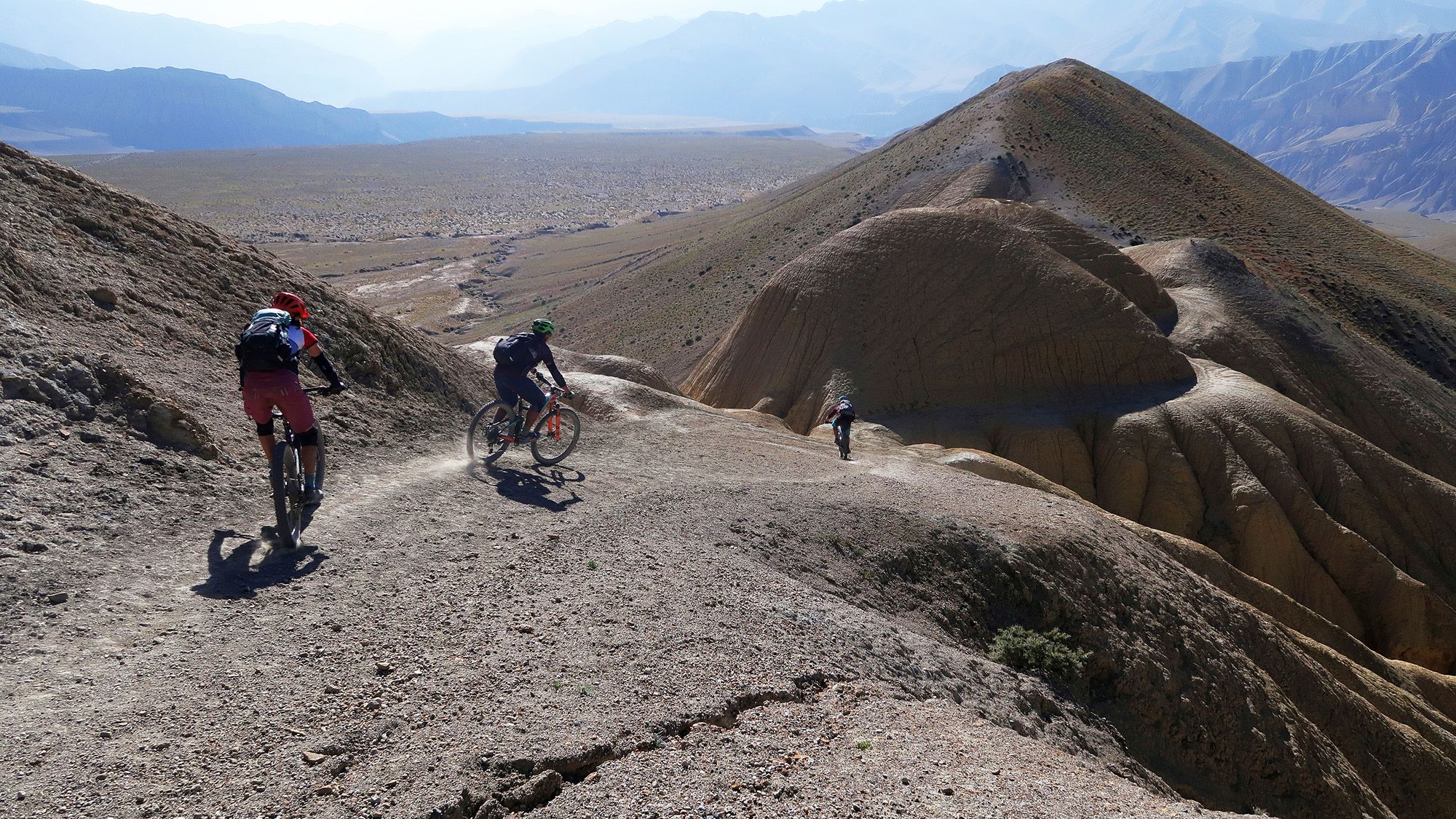 Eine Gruppe Mountainbiker, die einen Singletrail im Himalaya fahren.