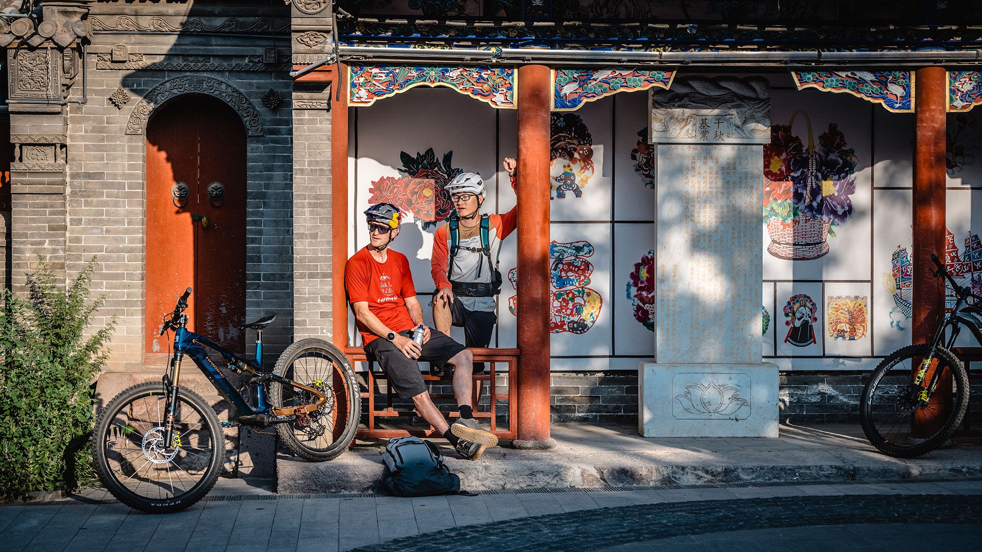 Zwei Mountainbiker machen eine Pause in einem chinesischen Tempel.