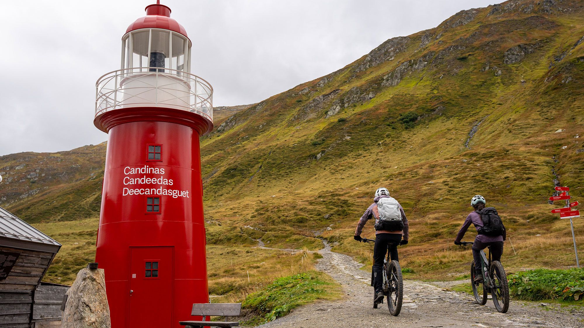 Zwei Mountainbiker fahren entlang eines Leuchtturms in der Schweiz.