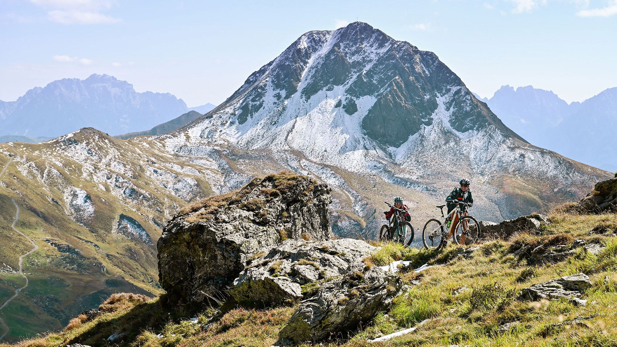 Zwei Mountainbiker schieben einen Trail hinauf.