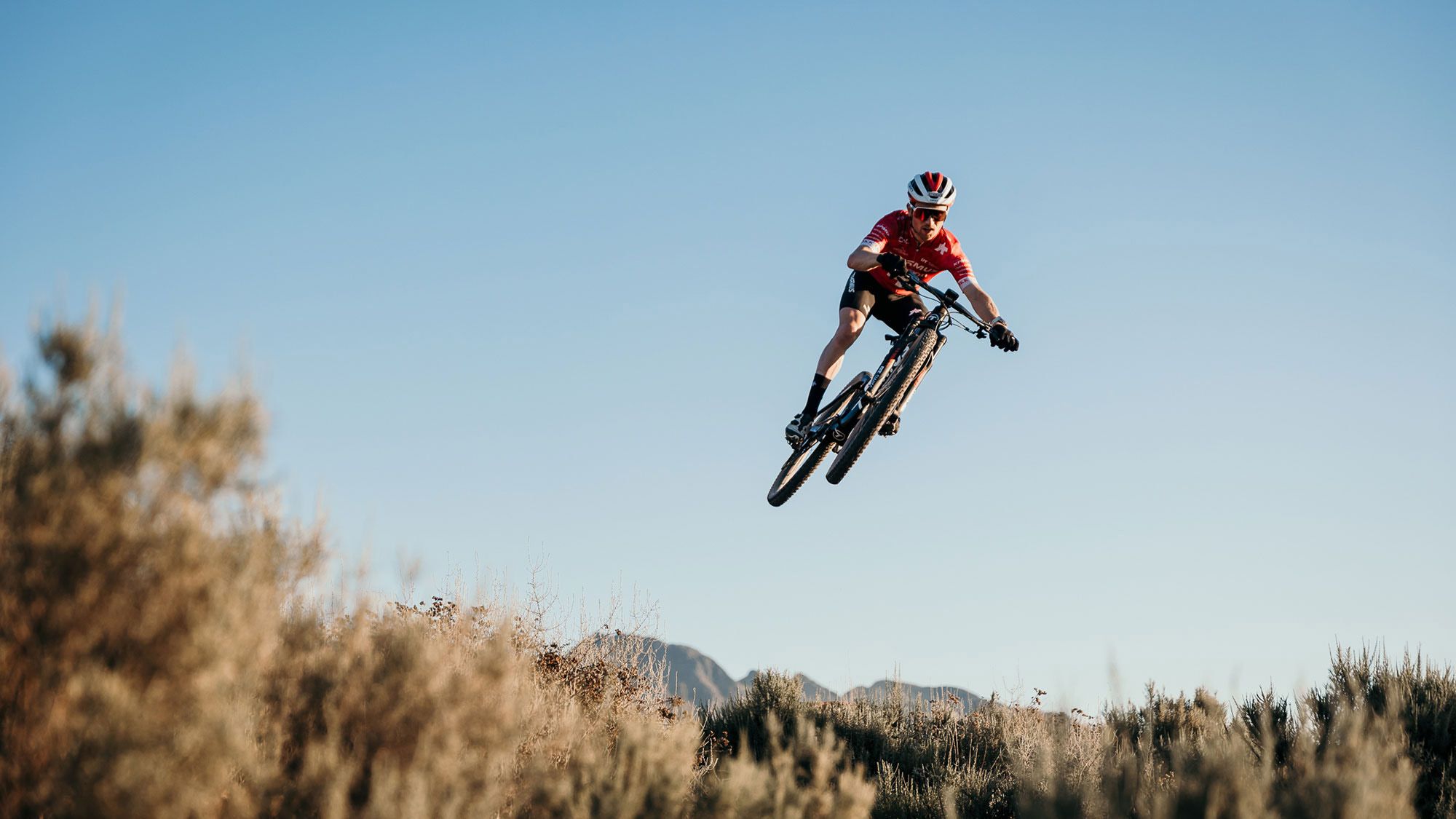Ein Mountainbiker fliegt durch die Luft.