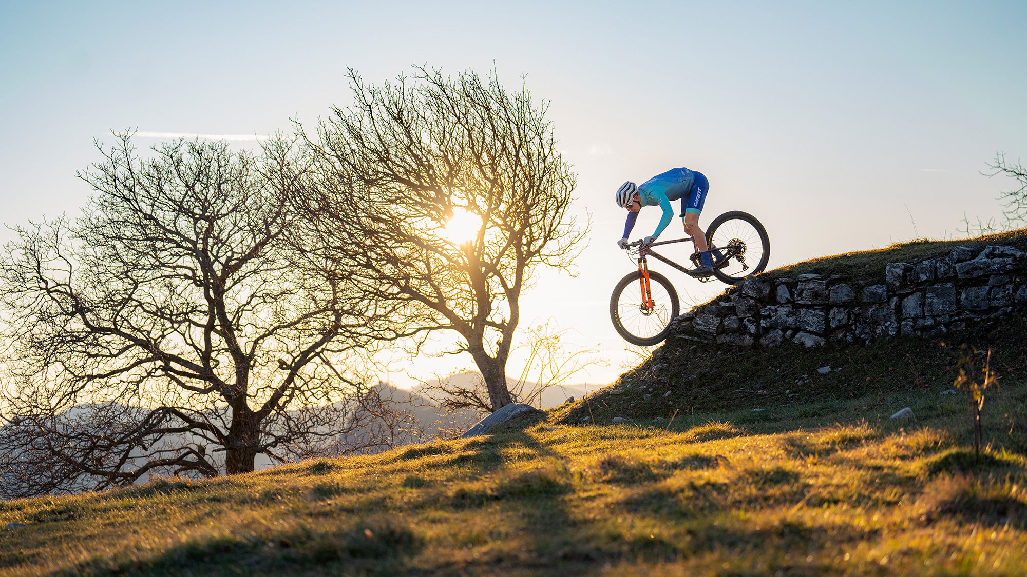 Ein Mountainbiker fährt einen steinernen Wall hinunter.
